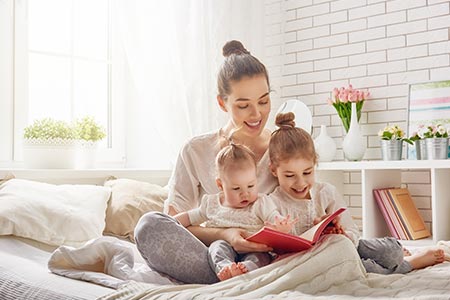 Women and children reading books in a room with fresh air.
